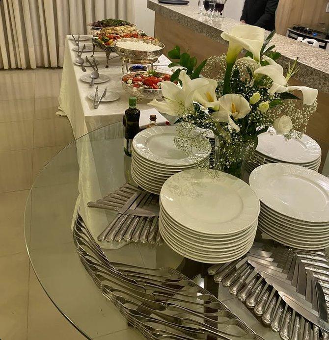 Mesa posta do Teixeira Buffet com pratos, talheres de prata e flores