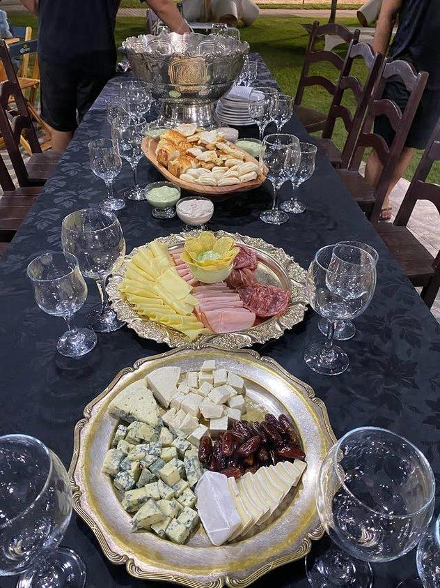 Tábuas de queijos e frios servidas em pratos de prata